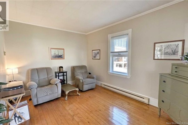 Living room with two recliners, a coffee table, and hardwood floors. - 216 Boul. Saint-pierre O, Caraquet