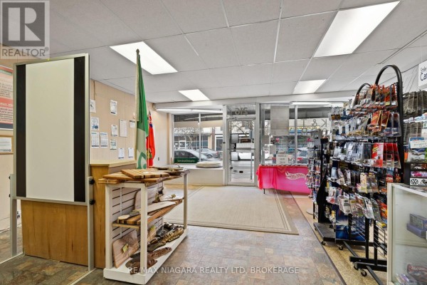 Interior view of a retail store with display shelves, a counter, and flags. - 216 King Street, Port Colborne