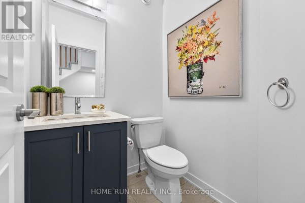 Powder room with dark blue vanity, white toilet, and floral artwork. - 216 Trumpeter Grove, Ottawa