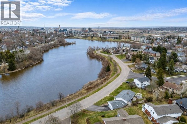 Aerial view of the property overlooking a curved river and residential neighborhood. - 216 Westmount Boulevard, Moncton