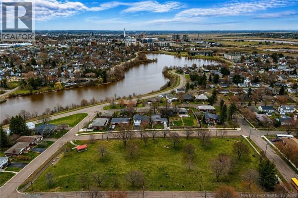 Aerial view of the neighborhood, parkland, and the distant city skyline across the river. - 216 Westmount Boulevard, Moncton