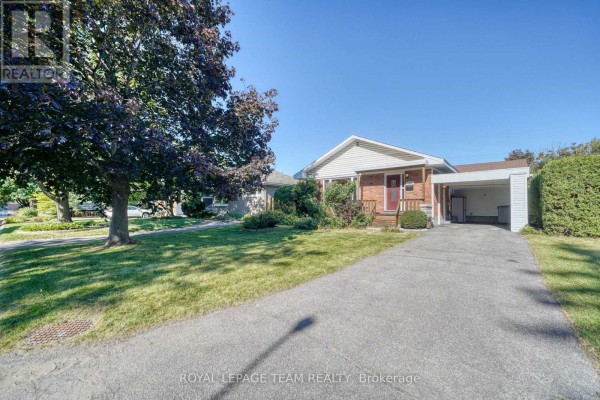 View of the house from the street showing a large tree in the front yard. - 2161 Rushton Road, Ottawa