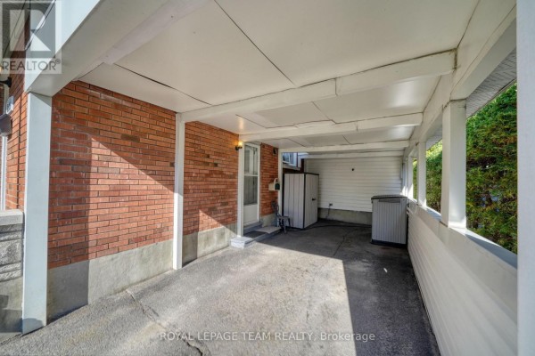 Covered carport attached to the brick house with a storage unit and outdoor AC. - 2161 Rushton Road, Ottawa