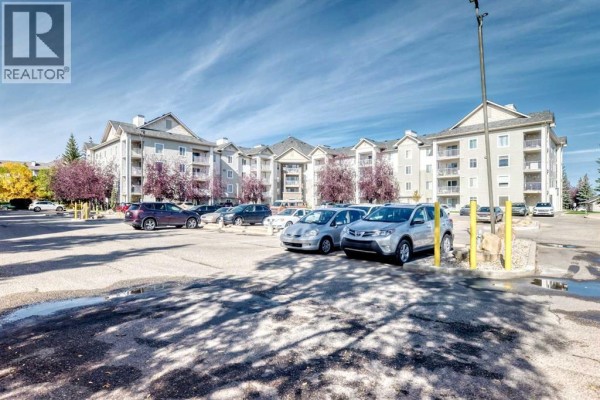 Apartment building exterior with a full parking lot in the foreground. - 217, 2000 Somervale Court Sw, Calgary