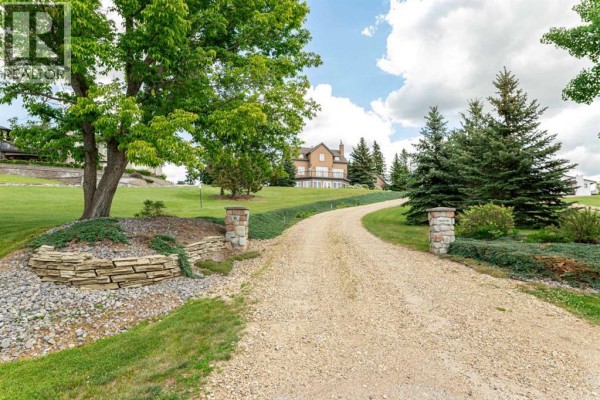 Living room with a stone fireplace, wooden accents, and modern furnishings. - 217, 27111 Highway 597, Rural Lacombe County