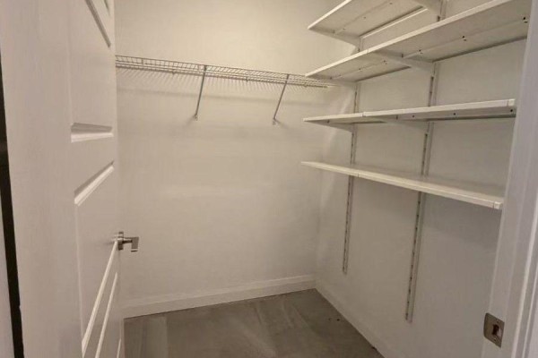 Walk-in closet with wire shelving and ample storage space in a white room. - 217 - 15 Water Walk Drive, Markham