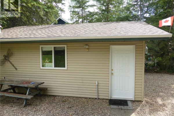 Exterior of a small building with a door and picnic table nearby - 217 & 221 Birch Drive, Turtle View
