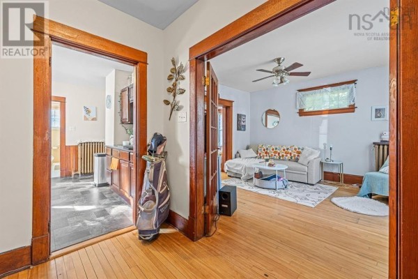View into a living room with a couch and coffee table, and a glimpse of the kitchen. - 217-219 Albert Street, New Glasgow