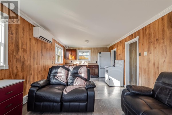 Open-concept living space with a kitchen area, appliances, and a washing machine. - 217 Admirals Cove Road, Admirals Cove