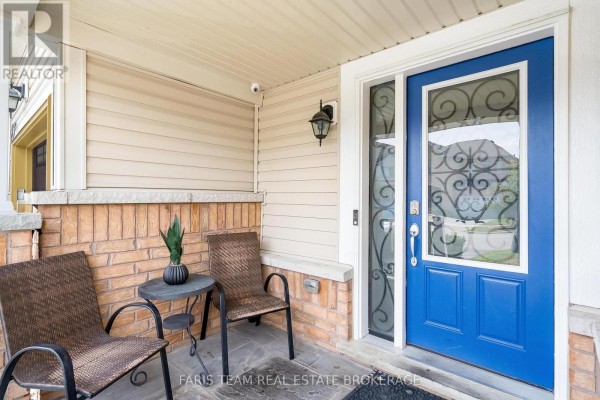 Covered front porch with two chairs and a small table next to a blue front door. - 217 Orr Drive, Bradford West Gwillimbury