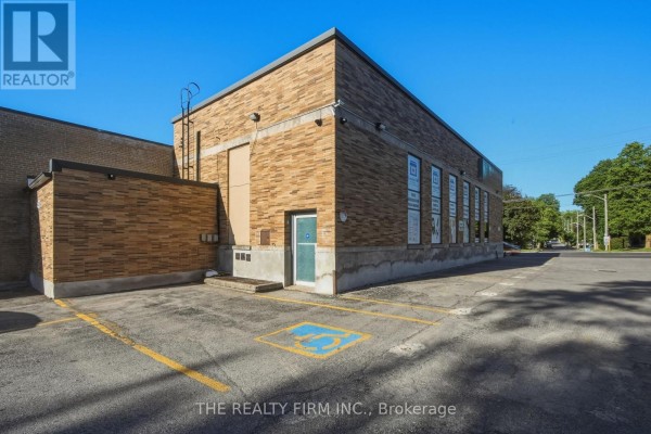 Side view of the commercial building with a parking lot and accessible parking space. - 217 Wharncliffe Road S, London South