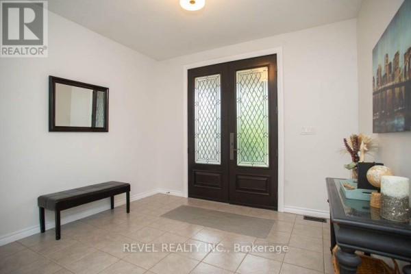 Foyer with tiled floor, dark double doors with glass panels, and a black leather bench. - 217 Woodway Trail, Norfolk