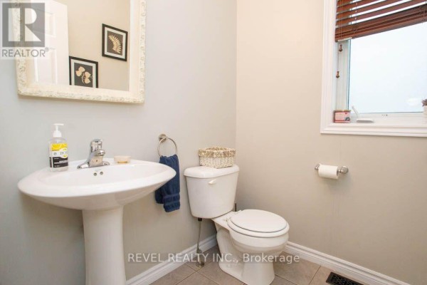 Powder room with a pedestal sink, toilet, and a window with horizontal blinds. - 217 Woodway Trail, Norfolk