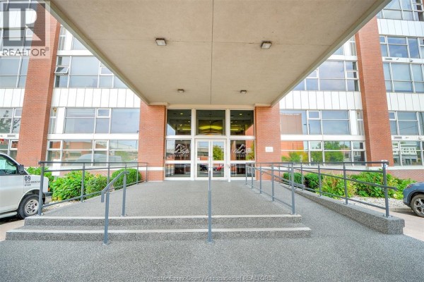 Accessible entrance ramp leading to the glass doors of an apartment building. - 2175 Wyandotte Street East Unit# 105, Windsor