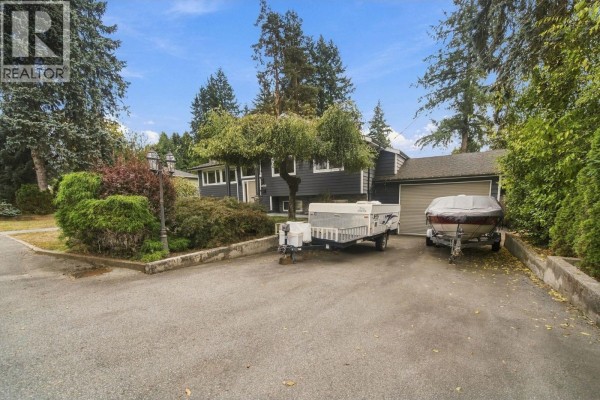 Driveway with a pop-up camper and a boat on a trailer parked next to a garage. - 21768 117 Avenue, Maple Ridge