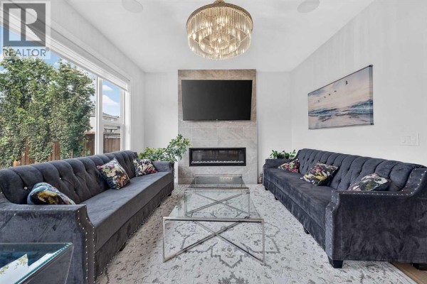 A room with floor seating, patterned cushions, a rug, and a chandelier. - 2177 Ravensdun Crescent Se, Airdrie