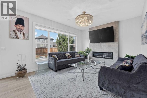 View from a room with floor seating into an open concept kitchen and dining area. - 2177 Ravensdun Crescent Se, Airdrie