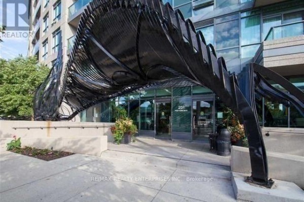 Modern condo building entrance with a black abstract metal canopy over glass doors. - 218 - 231 Fort York Boulevard, Toronto