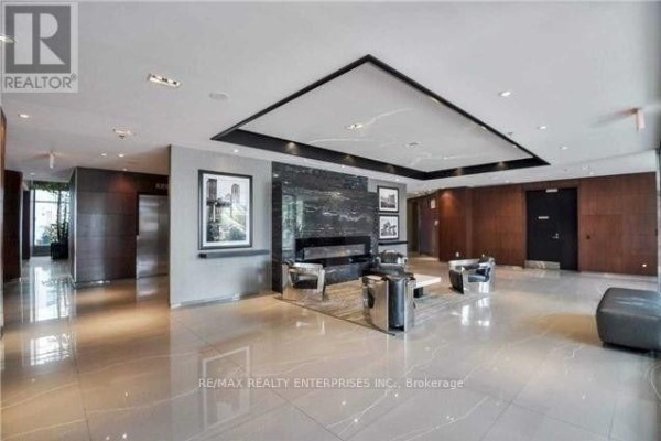 Contemporary lobby with marble floors, a fireplace, and modern seating areas. - 218 - 231 Fort York Boulevard, Toronto