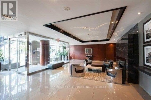 Lobby with a revolving glass door entrance, marble floors, and modern seating areas. - 218 - 231 Fort York Boulevard, Toronto