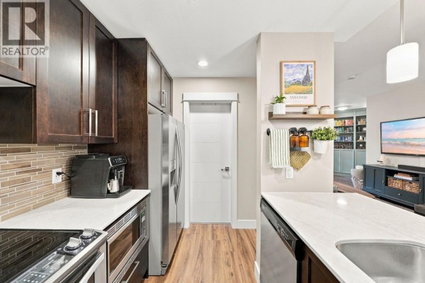 Kitchen view showing dark cabinets, stainless steel appliances, and a subway tile backsplash. - 218 2495 Wilson Avenue, Port Coquitlam