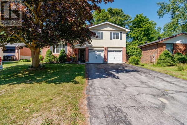 Exterior view of the house with double garage and driveway, surrounded by trees. - 218 Datas Drive, Clearview