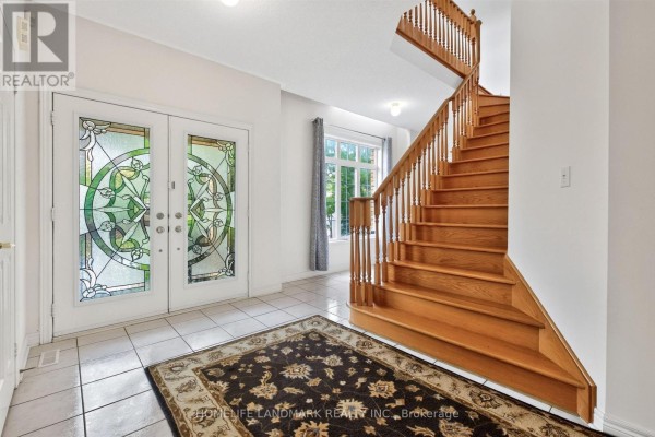 Interior foyer with white tiled floor, patterned rug, and a wooden staircase. - 218 Ridgecrest Road, Markham