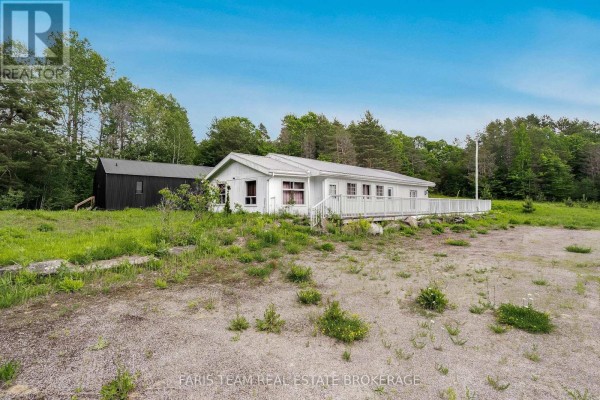 Open interior space with unfinished drywall and multiple windows. - 2180-2186 Hwy 141, Muskoka Lakes