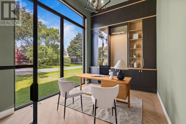 Home office with large windows, wooden desk, chairs, and built-in shelving. - 2186 Harcourt Crescent, Mississauga