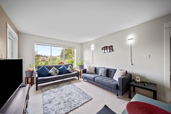 Side view of a multi-story apartment building with balconies and manicured lawn. - 219 32725 George Ferguson Way, Abbotsford