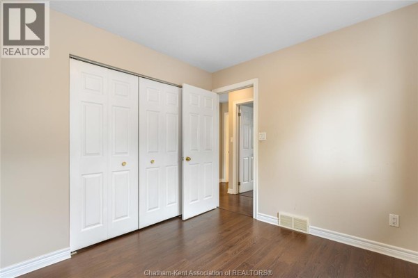 Bedroom with hardwood floors and double closet doors - 219 Greenfield Lane Chatham