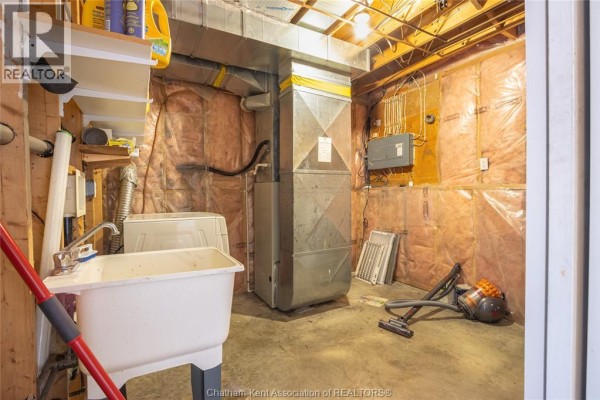 Utility sink, washer, furnace, AC unit in basement laundry room - 219 Greenfield Lane Chatham