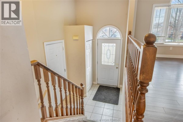 Entryway with front door, arched window, and wooden staircase - 219 Greenfield Lane Chatham