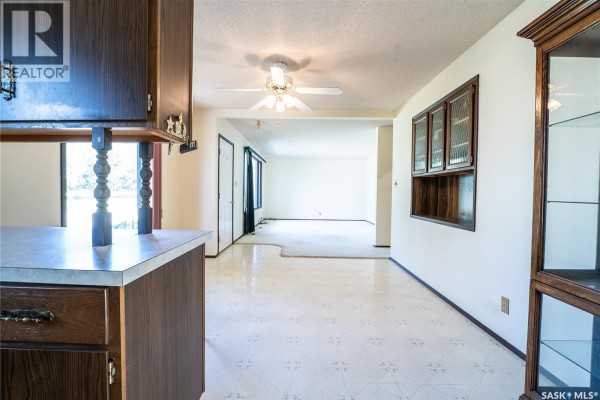 View from kitchen into dining area and living room with carpet. - 219 Railway Avenue W, Blaine Lake