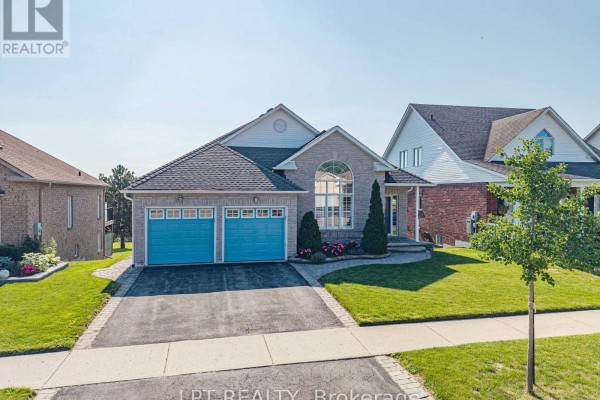 Aerial view of a detached brick house with a double garage and lawn. - 219 Waterbury Crescent, Scugog