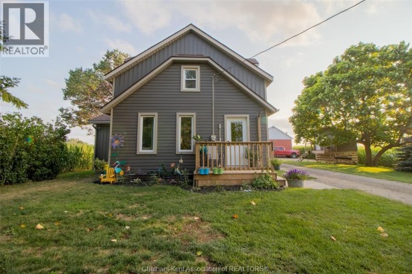 Corner view of a dark gray house with a white door and wooden porch. - 21956 Charing Cross Road, Charing Cross
