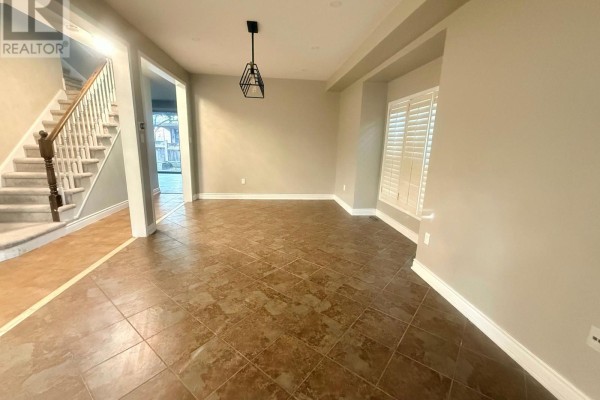 Living room and kitchen area with light gray flooring, large windows, and dark wood cabinets. - 2198 Woodglen Crescent, Burlington