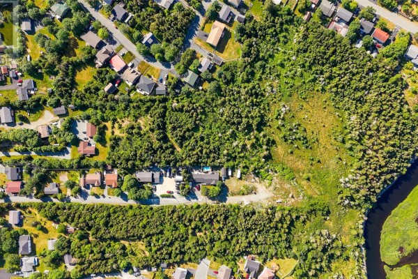Overhead aerial view of a wooded property with a river, showing surrounding residential streets and houses. - 21a Chamberlains Road, Conception Bay South
