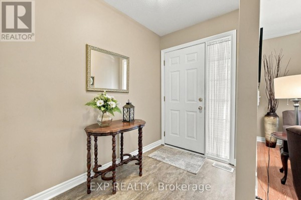 Entryway with a white door, beige walls, wood console table, and mirror. - 22 - 3241 Montrose Road, Niagara Falls