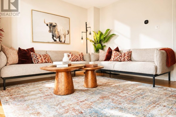 Living room with a sectional sofa, patterned throw pillows, and wooden coffee tables on a large rug. - 22 - 580 Eyer Drive, Pickering