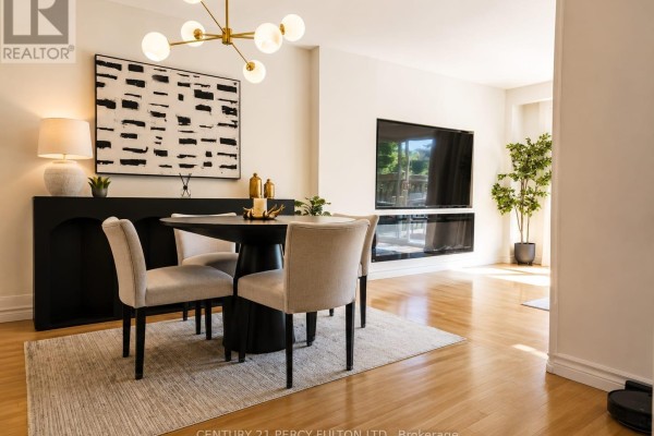 Dining area with a round table, four chairs, fireplace, and mounted television on a wall. - 22 - 580 Eyer Drive, Pickering