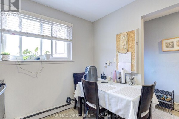 Dining area adjacent to the kitchen with a table, chairs, and a window. - 22 - 83 Irwin Road, Toronto