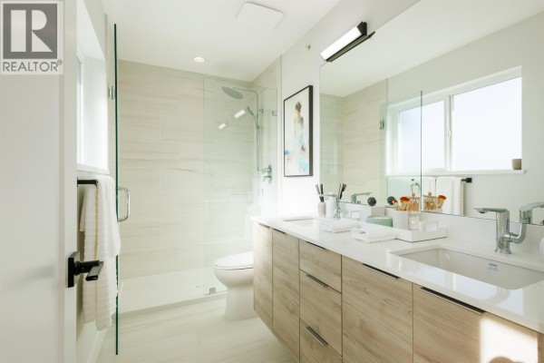 Spa-like bathroom featuring a walk-in shower, double vanity with wood cabinets, and large mirror. - 22 10640 248 Street, Maple Ridge