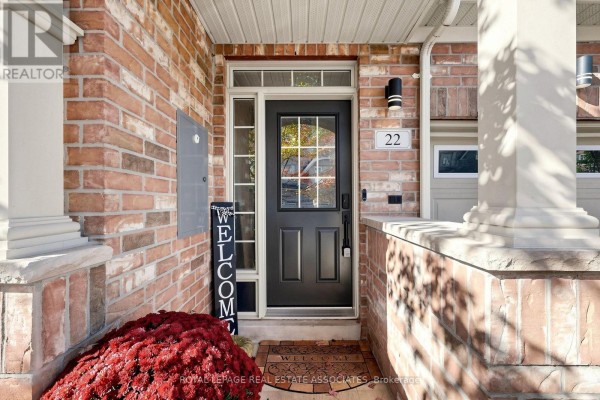 Close-up of the black front door of a townhouse, with sidelights and brick facade. - 22 Benjamin Way, Whitby