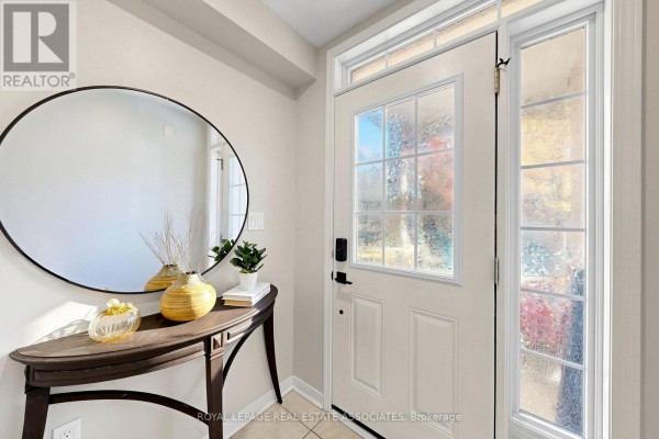 Interior view of the front foyer, showing a cream door, mirror, and console table. - 22 Benjamin Way, Whitby