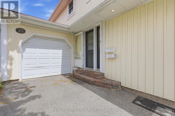 Close-up of the house entrance showing a white garage door, brick steps, and a front door. - 22 Bent Oak Circle, Mississauga