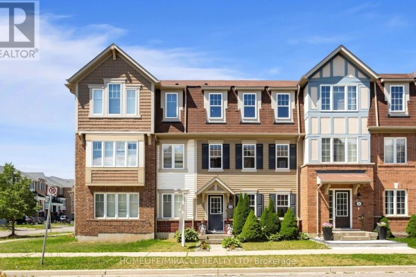 Exterior of attached townhouses with brown roofs, beige siding, and brick accents. - 22 Crossbill Road, Brampton