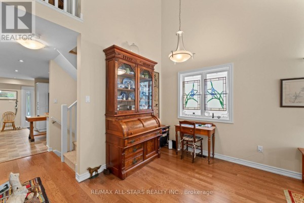 Interior view of a bright foyer with a white front door and adjacent windows. - 22 Deane Street, Kawartha Lakes
