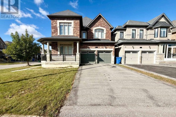 View of the front exterior of a large brick and stone house with a paved driveway. - 22 Duggan Street, Aurora