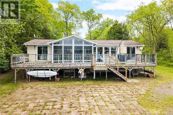 Rear exterior of a house with a large wooden deck and screened-in porch. - 22 Grandview Court, Whites Cove